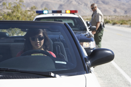 Lady getting pulled over in a convertible by a police officer.