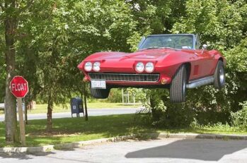 A floating red convertible car next to a red sign that says "Float."