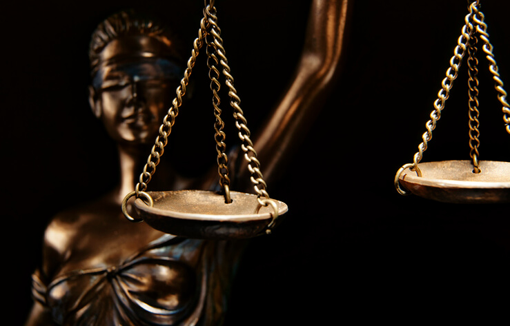 The blind lady of Justice holds up the scales.