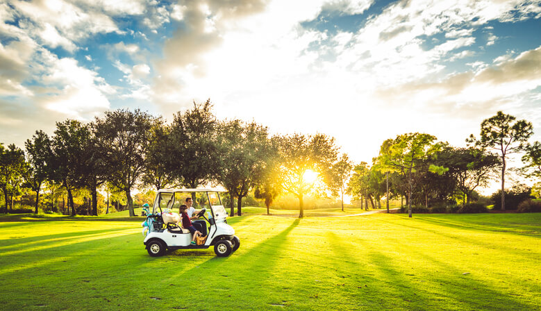 Father and daughter drive on scenic golf course in West Palm Beach Florida