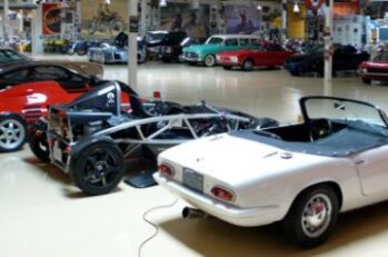 A garage with a bunch of fancy collector cars inside of it.