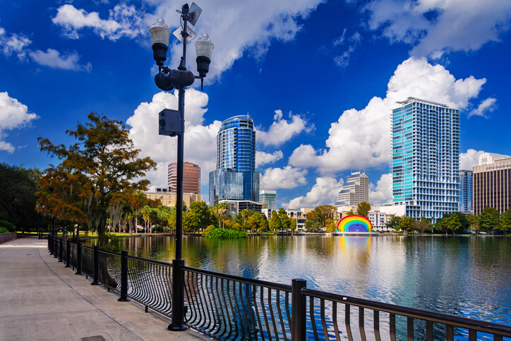 Downtown Orlando skyline view with Lake Eola and a footpath in the foreground, and with a dramatic cumulus could and blue sky background.