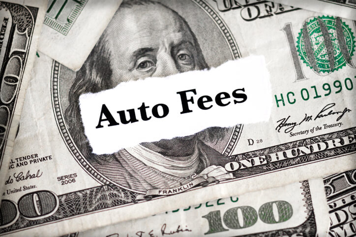 The words "Auto Fees" with hundred dollar bills in the background.