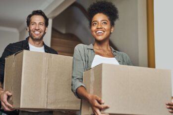 A couple walks happily through a doorway on moving day, confident in the fact that they've handled the Florida Driver's License change of address.