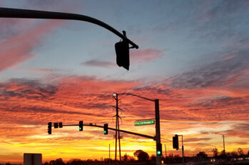 A beautiful Arizona sunset behind a red light at an intersection.