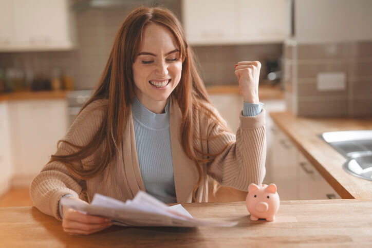 A woman celebrates as she calculates her auto insurance savings based on her affiliation discount.